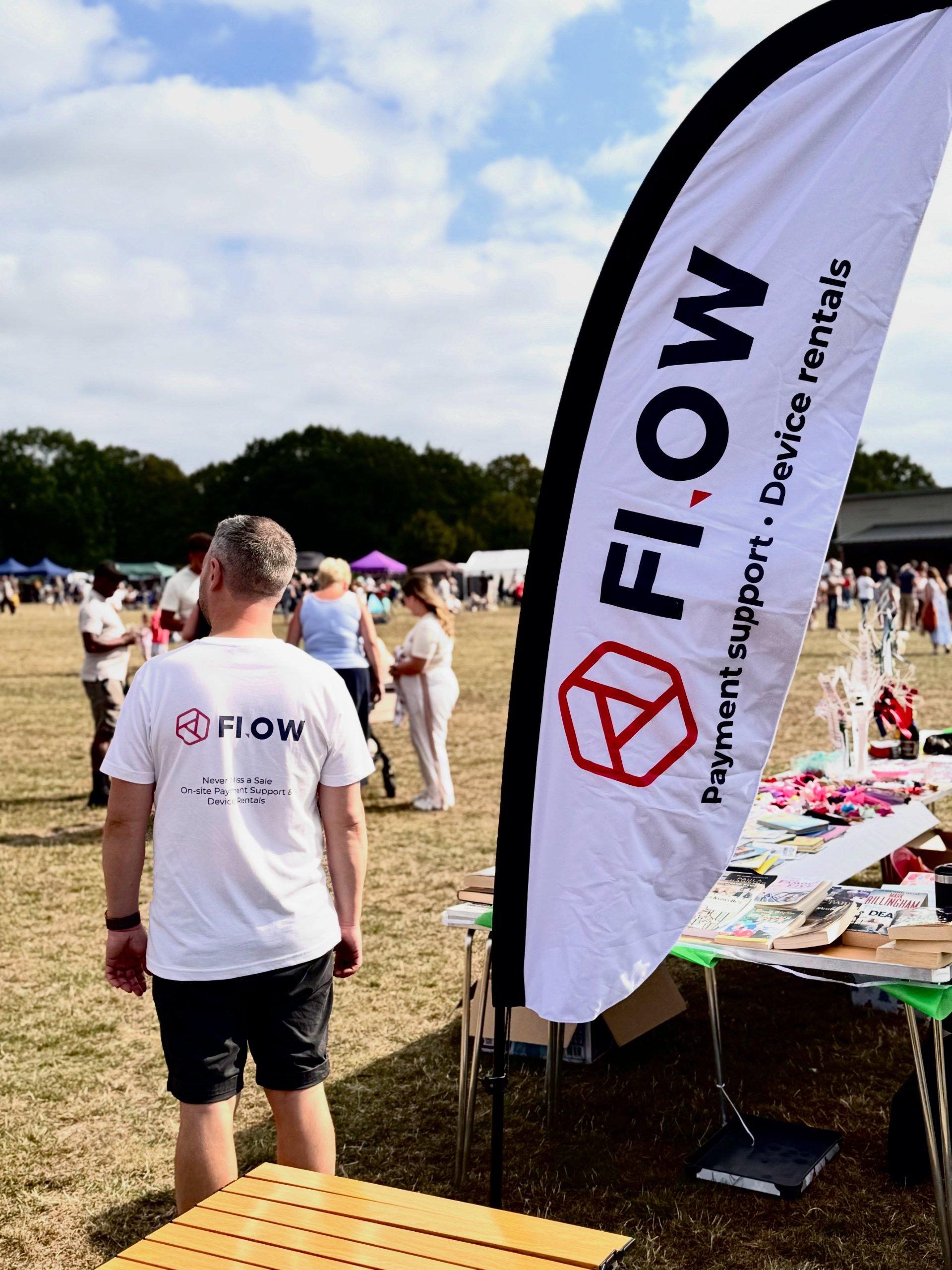 The Flow flag and team at a busy outdoor market