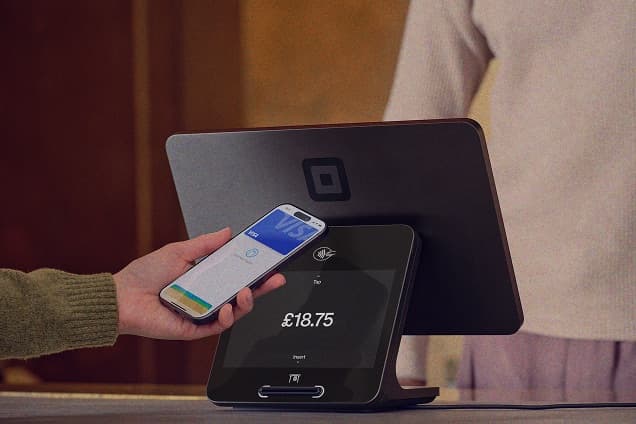 A customer paying by phone at a Square Register till